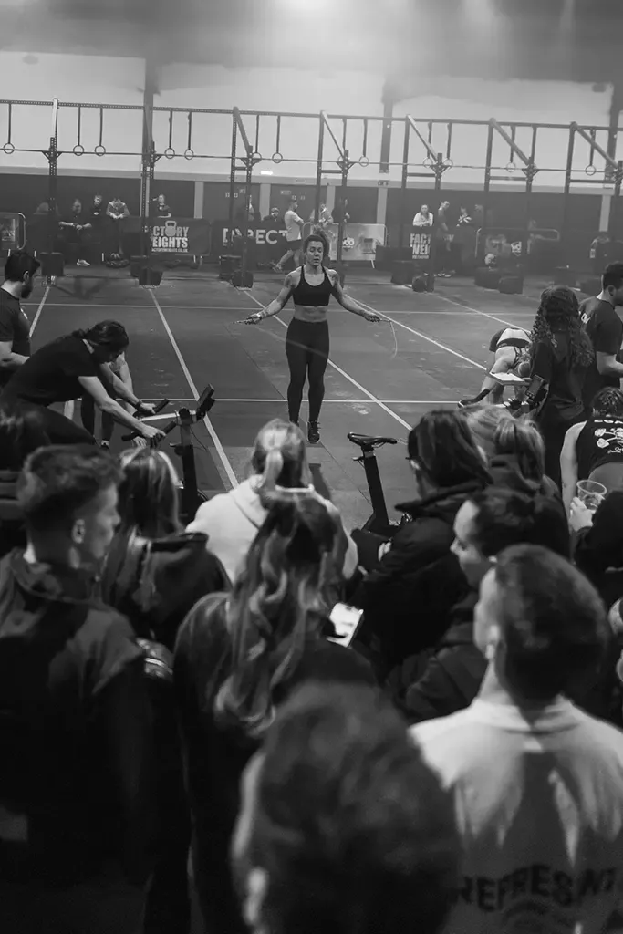 athlete at a crossfit competition performing double unders surrounded by supports from the gym